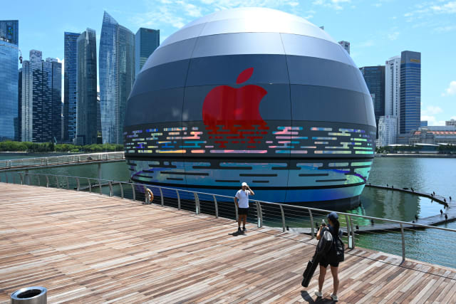 A woman takes a photograph for a friend in front of the new Apple store, located in the water in front of the Marina Bay Sands, in Singapore on August 24, 2020. (Photo by Roslan RAHMAN / AFP) (Photo by ROSLAN RAHMAN/AFP via Getty Images)