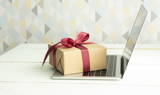 tenant une boîte cadeau rouge sur le concept de shopping en ligne.
