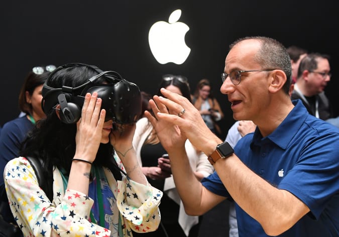Un employé d'Apple aide un membre des médias à essayer un HTC Vive tout en testant les capacités de réalité virtuelle du nouvel iMac lors de la conférence mondiale des développeurs d'Apple à San Jose, Californie, le 5 juin 2017. / AFP PHOTO / Josh Edelson (Le crédit photo devrait lire JOSH EDELSON/AFP via Getty Images)