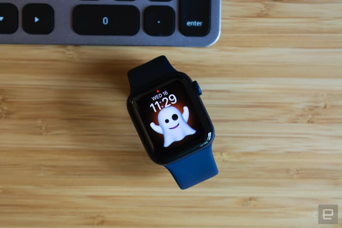 Apple Watch Series 6 with Memoji control face sitting on a wooden table.