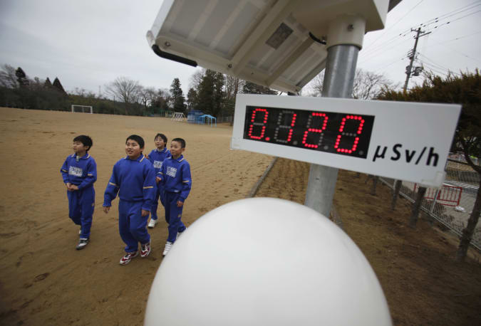 Students walk near a geiger counter, measuring a radiation level of 0.12 microsievert per hour, at Omika Elementary School, located about 21 km (13 miles) from the tsunami-crippled Fukushima Daiichi nuclear power plant, in Minamisoma, Fukushima prefecture, March 8, 2012, ahead of the one-year anniversary of the March 11 earthquake and tsunami. The reopened elementary school, which is the nearest one located to the crippled nuclear power plant, had 205 students before the March 11, 2011 disasters. However, only 91 students remained following its reopening on October 17, 2011. REUTERS/Toru Hanai (JAPAN - Tags: DISASTER ANNIVERSARY ENVIRONMENT)