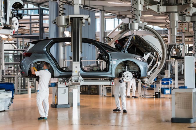 Employees work on the assembly line for the Volkswagen (VW) ID 3 electric car of German carmaker Volkswagen, at the 'Glassy Manufactory' (Glaeserne Manufaktur) production site in Dresden, eastern Germany on June 8, 2021. (Photo by JENS SCHLUETER / AFP) (Photo by JENS SCHLUETER/AFP via Getty Images)