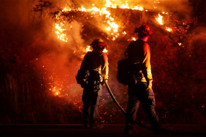 Firefighters extinguish spot fires along Route 89 Dixie Fire in Moccasin, now over 200,000 acres, California, U.S., July 28, 2021.  REUTERS/David Swanson     TPX IMAGES OF THE DAY