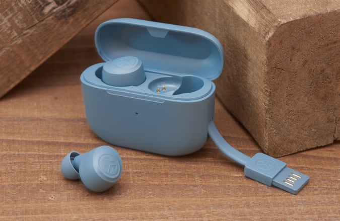 J-Lab Go Air Pop earbuds and charging case in light blue leaning on wood blocks.