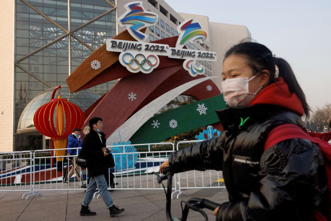 People walk past a display of the logos of the Beijing 2022 Winter Olympics and Paralympics in Beijing, China January 14, 2022. REUTERS/Thomas Peter