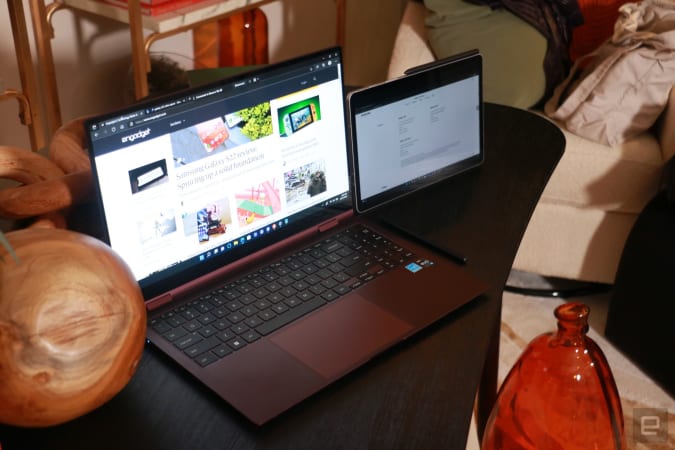 A Samsung Galaxy Book 2 Pro 360 on a wooden table with the Engadget website on its screen. To its right sits a Tab S8 with an S Pen on its top edge.