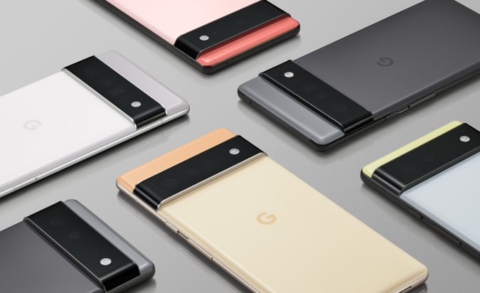 Six Google Pixel 6 Pro smartphones in various pastel colors on a gray table.