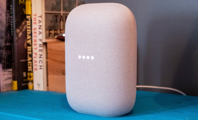 O alto-falante inteligente Google Nest Audio sobre uma mesa azul.