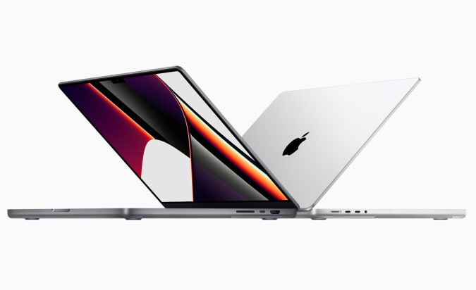Two of Apple's 14-inch MacBook Pro half open on a white background.