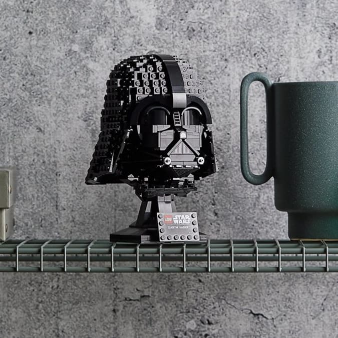 Darth Vader's face, made of LEGO, standing on a wire shelf.