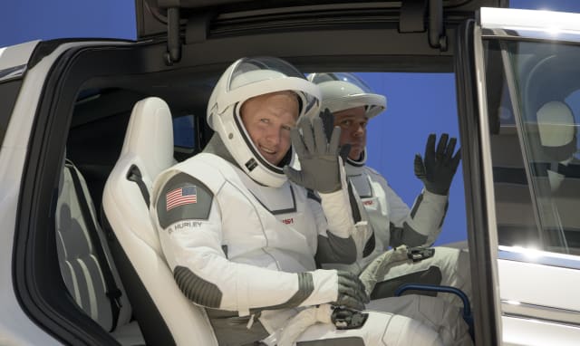 NASA astronauts Douglas Hurley, left, and Robert Behnken, wearing SpaceX spacesuits, depart the Neil A. Armstrong Operations and Checkout Building for Launch Complex 39A during a dress rehearsal prior to the Demo-2 mission launch, Saturday, May 23, 2020, at NASA's Kennedy Space Center in Cape Canaveral, Fla. The SpaceX Falcon 9 rocket, that will send two astronauts to the International Space Station for the first crewed flight from the U.S. in nearly a decade., is scheduled for launch on Wednesday, May 27. (Bill Ingalls/NASA via AP)