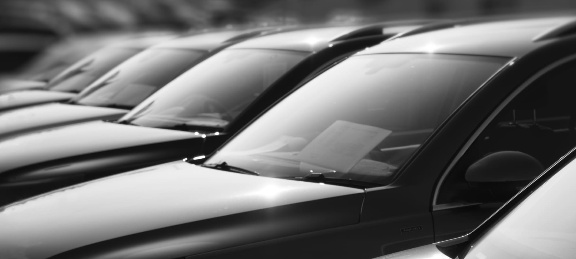 Row of used cars at a dealer - black and white