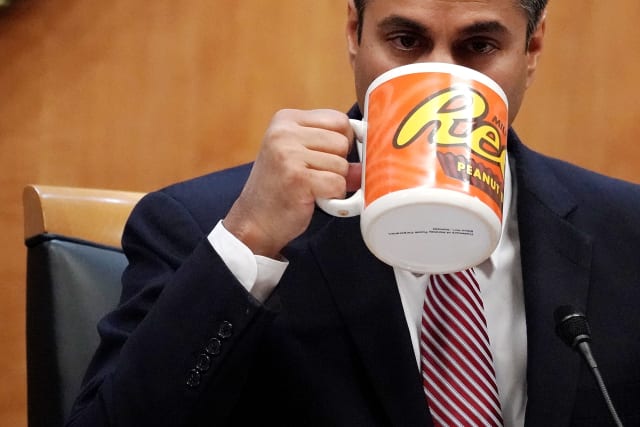 WASHINGTON, DC - DECEMBER 14: Federal Communications Commission Chairman Ajit Pai drinks from a big coffee cup during a commission meeting December 14, 2017 in Washington, DC. The FCC is scheduled to vote on a proposal to repeal net-neutrality. (Photo by Alex Wong/Getty Images)