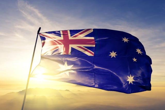 Australia Australian flag on flagpole textile cloth fabric waving on the top sunrise mist fog