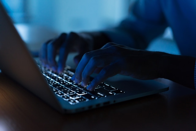 up close programmer man hand typing on keyboard laptop for register data system or access password at dark operation room , cyber security concept
