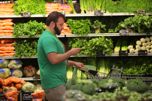 BOSTON, MA - MAY 28: Owen Amsler, an Instacart shift captain, shops for a customer in the Whole Foods Market in Boston's South End on May 28. 2015. A company called Instacart sends people into stores like Whole Foods to fulfill grocery delivery orders from other people. (Photo by Lane Turner/The Boston Globe via Getty Images)