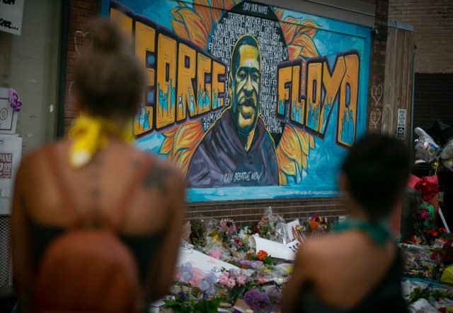 MINNEAPOLIS , MINNESOTA - MAY 31: People defy the curfew to pay their respects at the makeshift memorial and mural outside Cup Foods where George Floyd was murdered by a Minneapolis police officer on Sunday, May 31, 2020 in Minneapolis , Minnesota. (Jason Armond / Los Angeles Times via Getty Images)