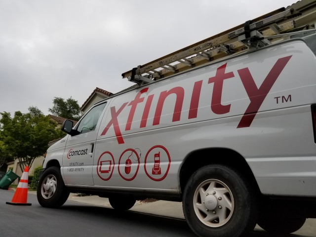 San Ramon, California, United States - May 17, 2018: Low angle view of Comcast Xfinity cable television installation truck parked on a street in front of a suburban home, San Ramon, California, May 17, 2018