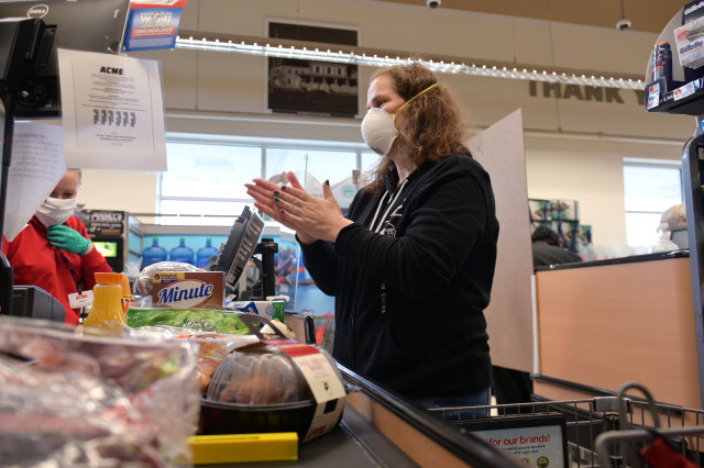 CLARK, NEW JERSEY - APRIL 27: Clark resident Jen Valencia sanitizes her hands at checkout as she supplements her income working for Instacart at Acme Market on April 27, 2020 in Clark, New Jersey. Instacart has experienced a massive surge in customer demand and employment recently due to lockdowns and other restrictions caused by COVID-19. (Photo by Michael Loccisano/Getty Images)