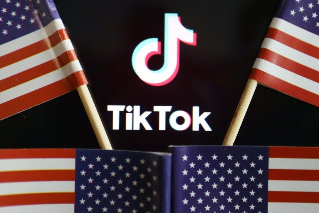 U.S. flags are seen near a TikTok logo in this illustration picture taken July 16, 2020. REUTERS/Florence Lo/Illustration