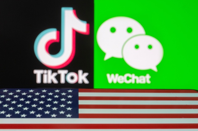A U.S. flag is seen on a smartphone in front of displayed Tik Tok and WeChat logos in this illustration taken September 18, 2020. REUTERS/Dado Ruvic/Illustration