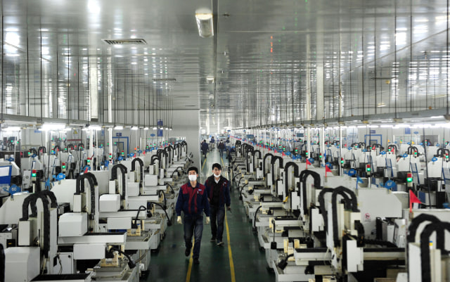 This picture taken on March 12, 2015 shows employees working in the workshop of Lens Technology in Liuyang, central China's Hunan province. Zhou Qunshu, a former factory worker who founded Lens Technology , a company supplying Apple, Samsung and other technological giants with touchscreen glass has become China's richest woman, reports said, with a fortune surpassing 8 billion USD.   CHINA OUT     AFP PHOTO        (Photo credit should read STR/AFP via Getty Images)