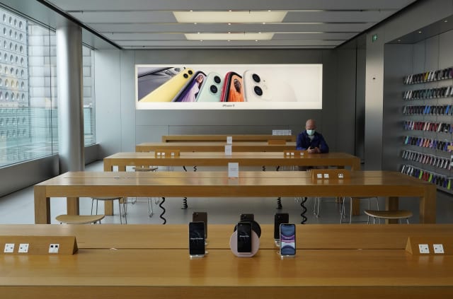A man wearing face mask sits at an Apple Store in Hong Kong Wednesday, April 1, 2020. For most, the coronavirus causes only mild or moderate symptoms, such as fever and cough. But for a few, especially older adults and people with existing health problems, it can cause more severe illnesses, including pneumonia. (AP Photo/Vincent Yu)