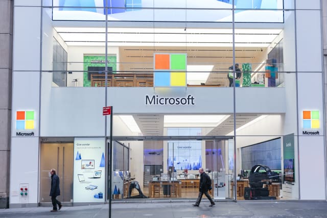 People walk past a Microsoft store entrance with the company's logo on top in midtown Manhattan at the 5th avenue in New York City, US, on 11 November 2019. Microsoft Corporation is world's largest software maker dominant in PC operating system Microsoft Windows, office applications, web browser and communication market. (Photo by Nicolas Economou/NurPhoto via Getty Images)